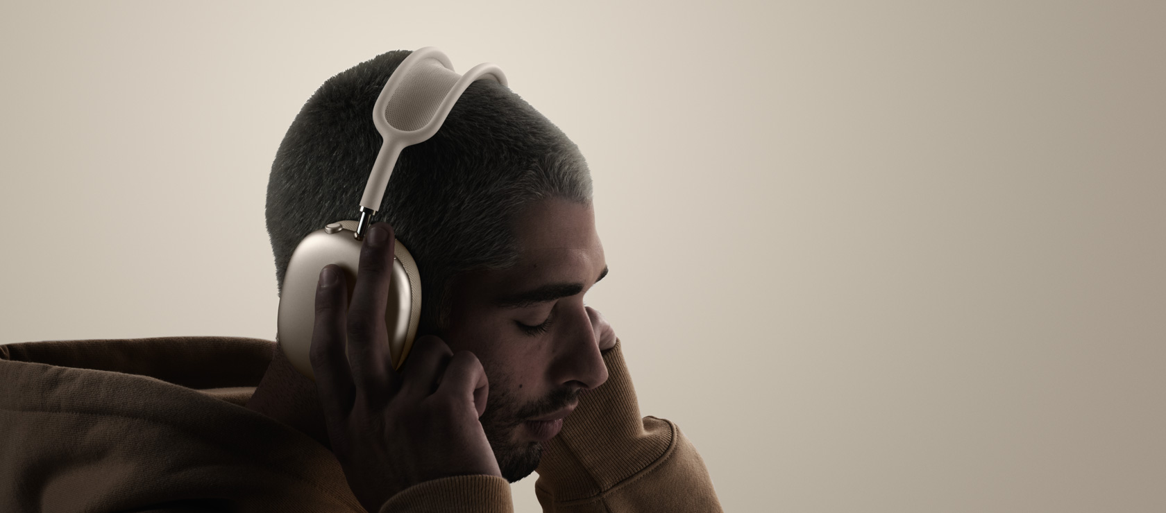 Mees kandmas AirPods Maxi ja puudutamas AirPods Maxi kõrvapatja..