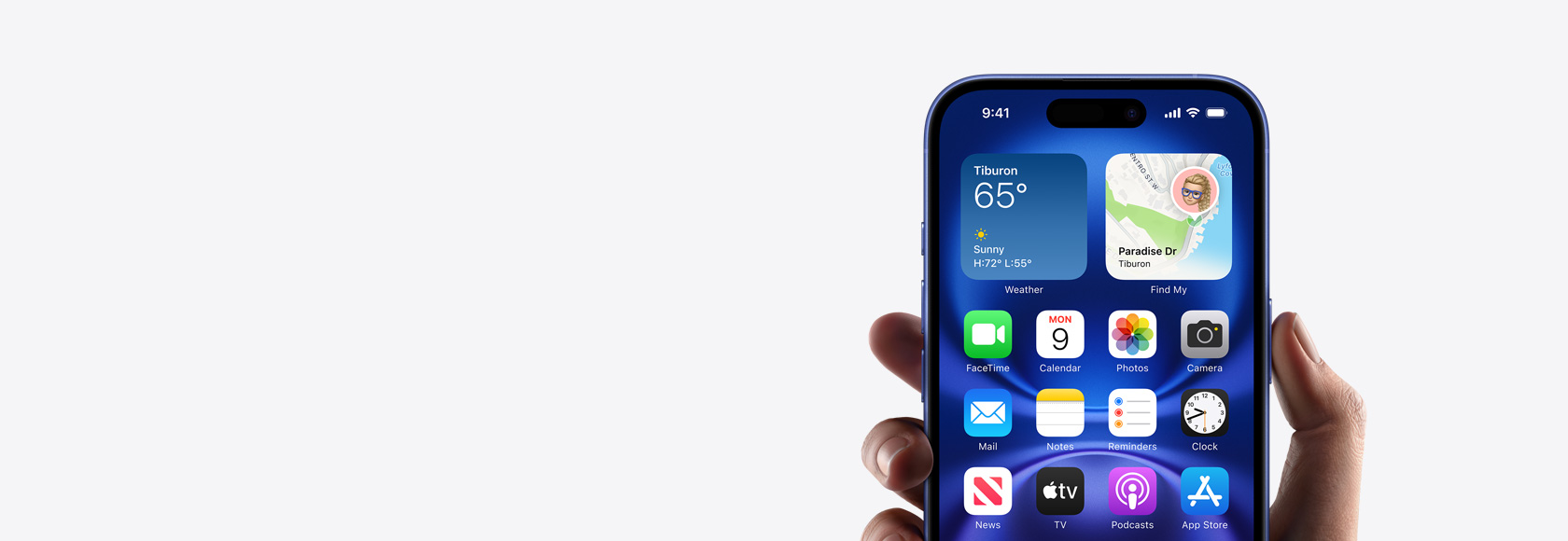 Hand holding iPhone 16 with screen showing Home screen photo, icons, and widgets.
