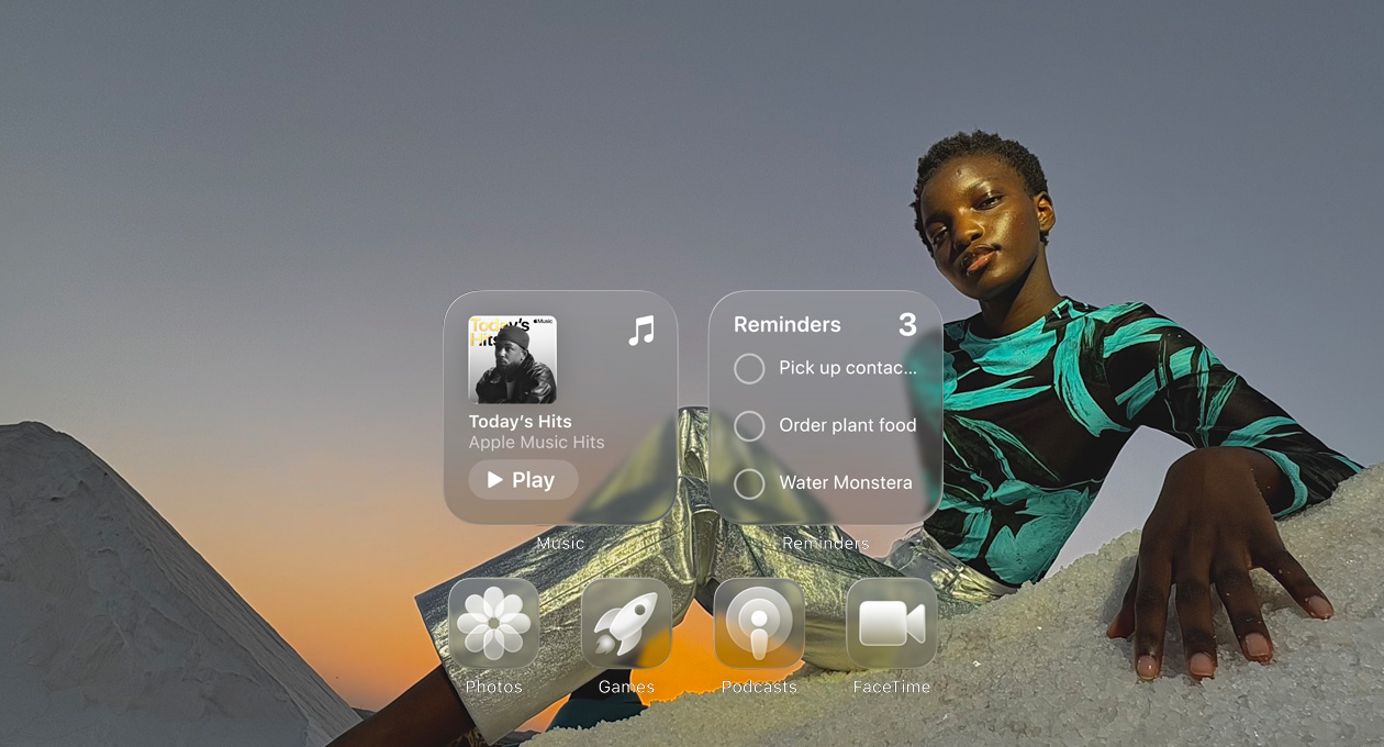 Tela em Liquid Glass com ícones de apps transparentes, como Apple Music, Lembretes, Fotos, Games, Podcasts e FaceTime, que criam um efeito de refração no papel de parede.