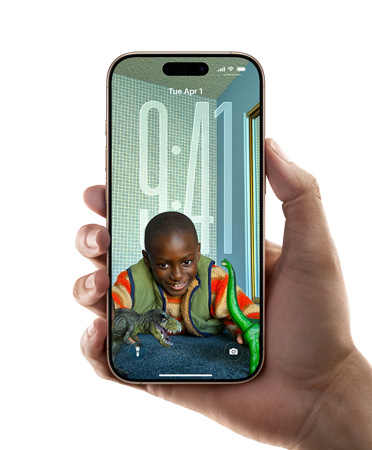 Uma mão segurando um iPhone que mostra a tela com o novo design de Liquid Glass, que faz as horas se adaptarem dinamicamente à imagem da tela bloqueada.